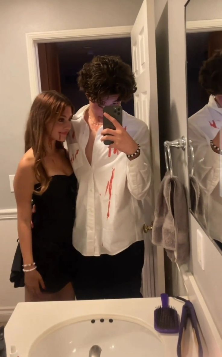 a man taking a selfie in front of a mirror while standing next to a woman