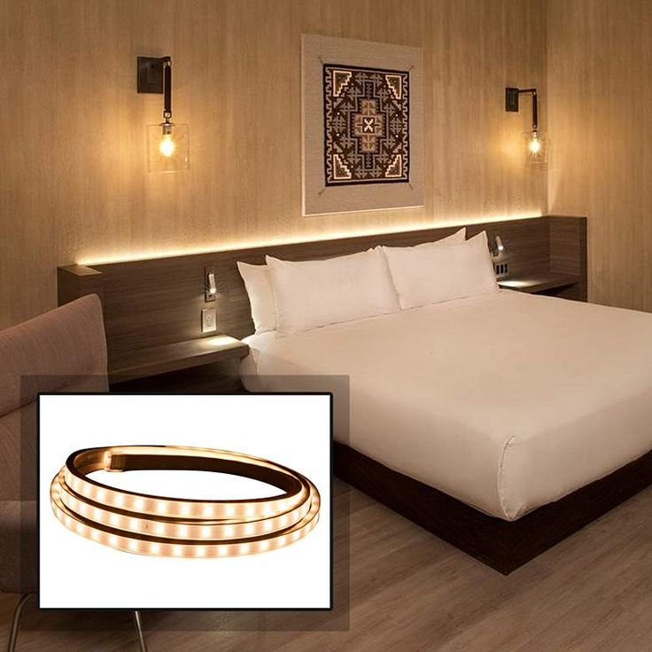 there is a bed that has some lights on the headboard and in front of it