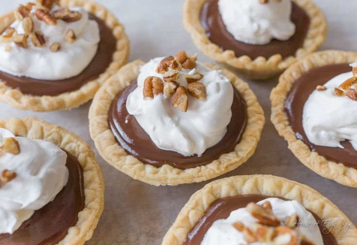 chocolate pies with whipped cream and pecans on top