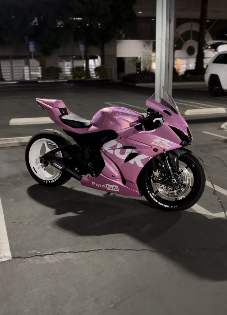 a pink motorcycle parked in a parking lot