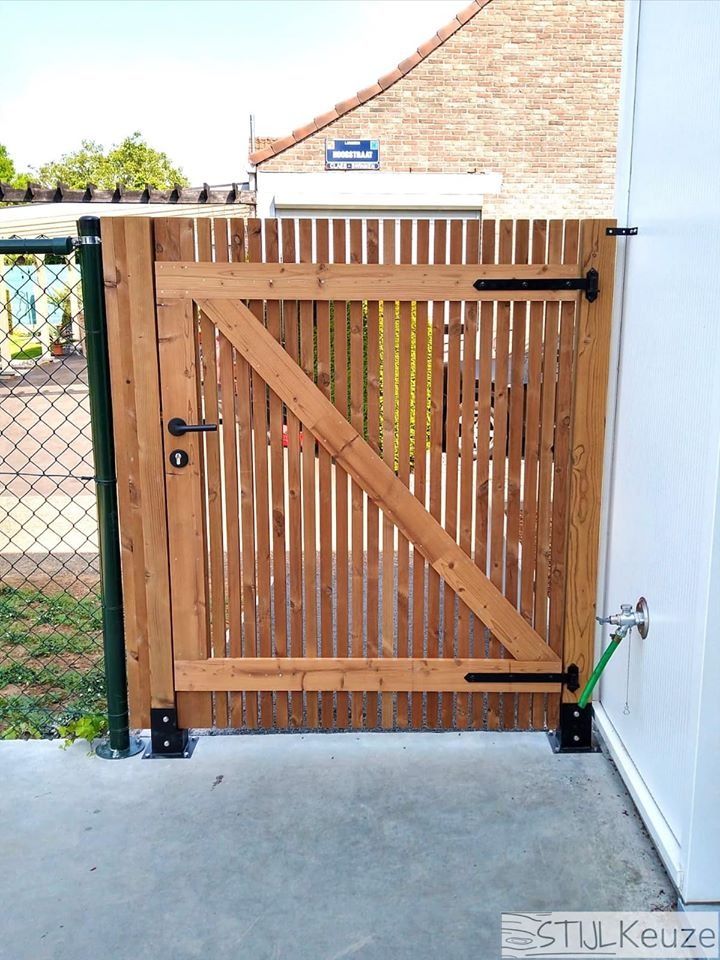 a wooden gate is open on the side of a building