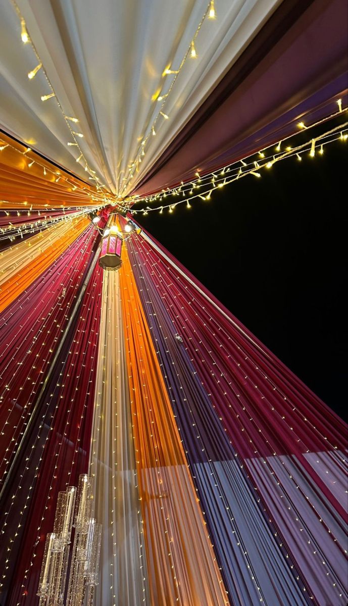 the ceiling is decorated with lights and streamers in red, orange, yellow and white