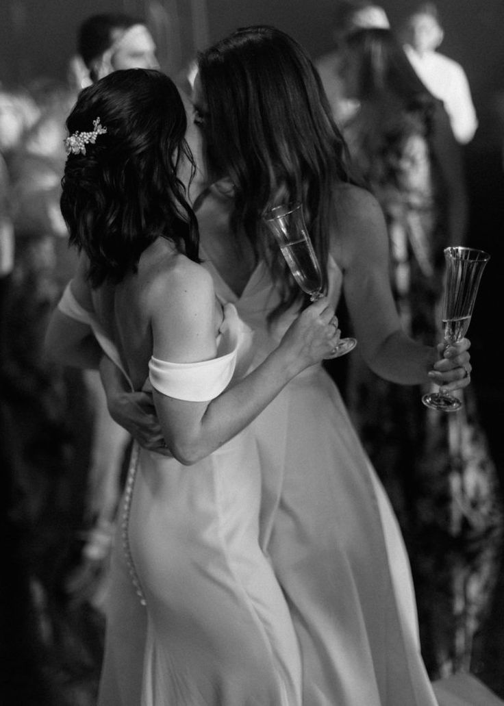 black and white photograph of two brides sharing a kiss on the dance floor at their wedding