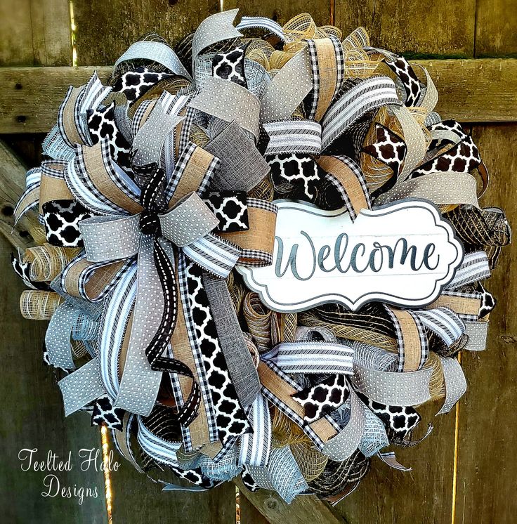 a welcome wreath is hanging on a wooden door