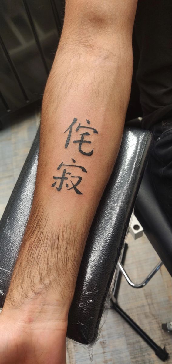 a man's arm with chinese writing on it