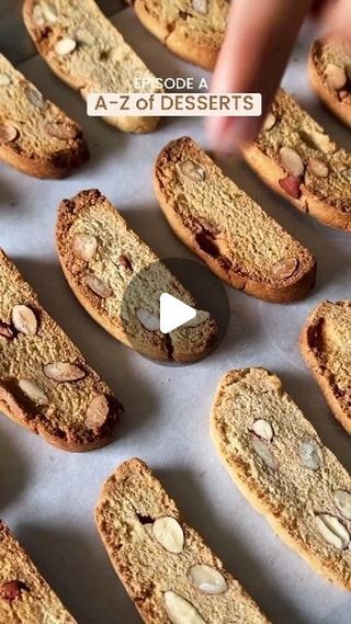 cookies with almonds are arranged in rows on a baking sheet, and then being sliced into smaller pieces