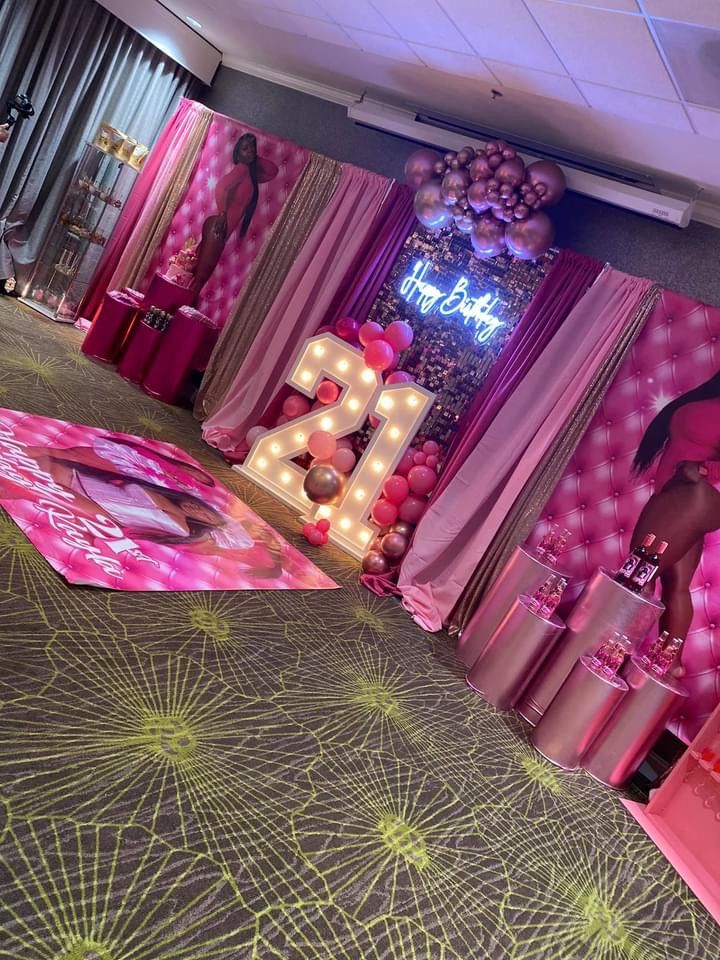 the room is decorated in pink and gold with balloons on the floor, decorations and lights