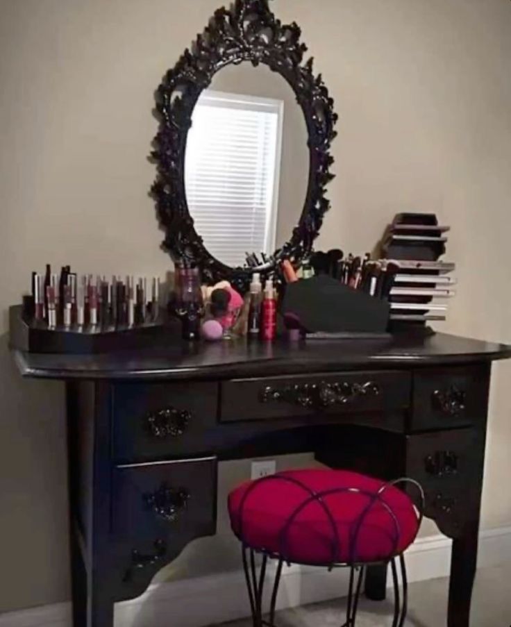 a desk with a mirror, stool and various items on it