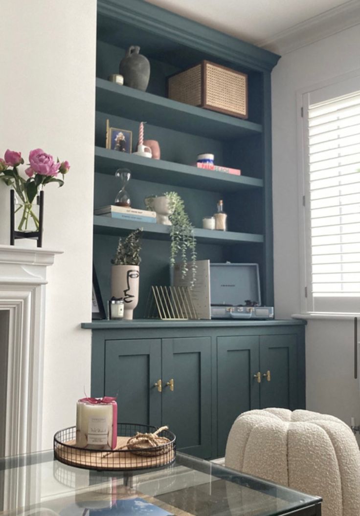 a living room with a fireplace and shelves