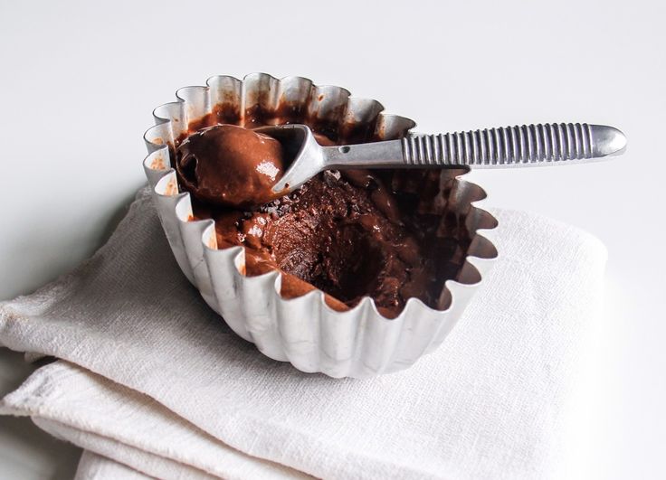 a chocolate cupcake in a paper container with a spoon