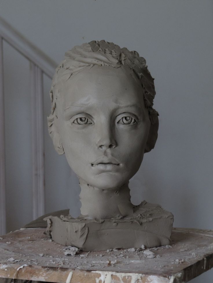 a clay sculpture of a woman's head on top of a table