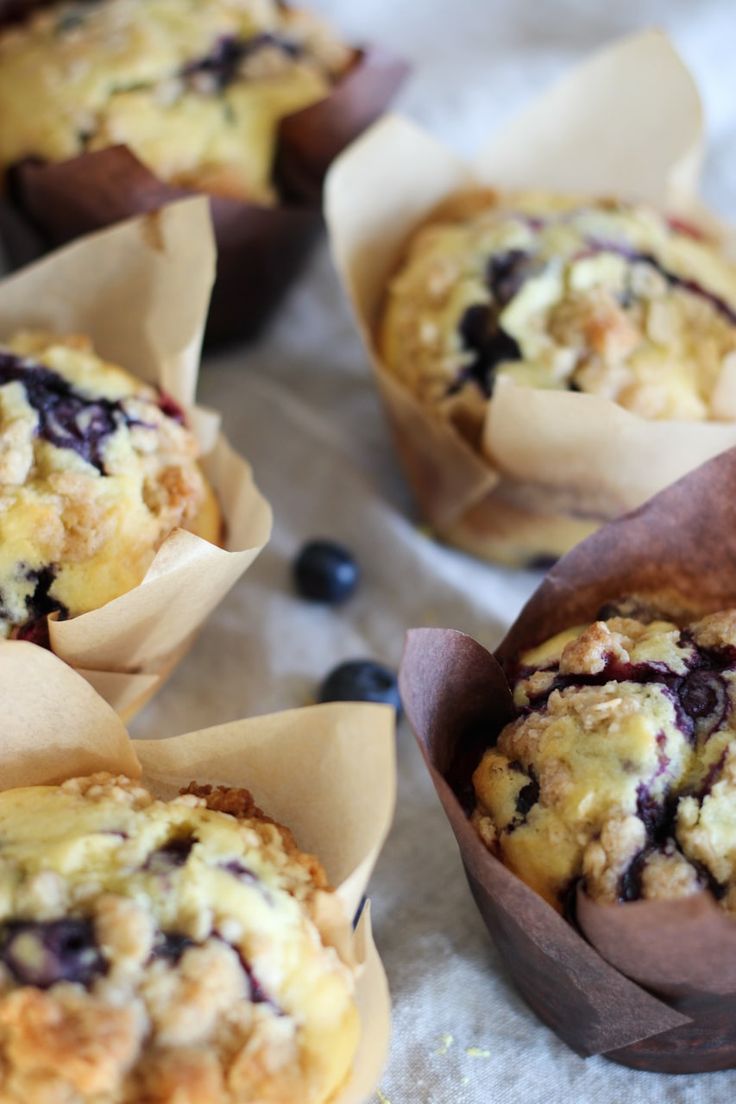 blueberry muffins are sitting in paper wrappers