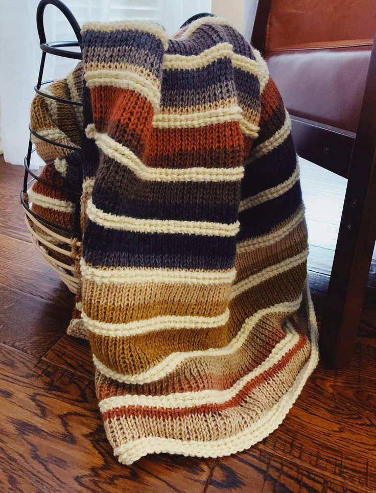 a blanket sitting on top of a wooden floor next to a chair