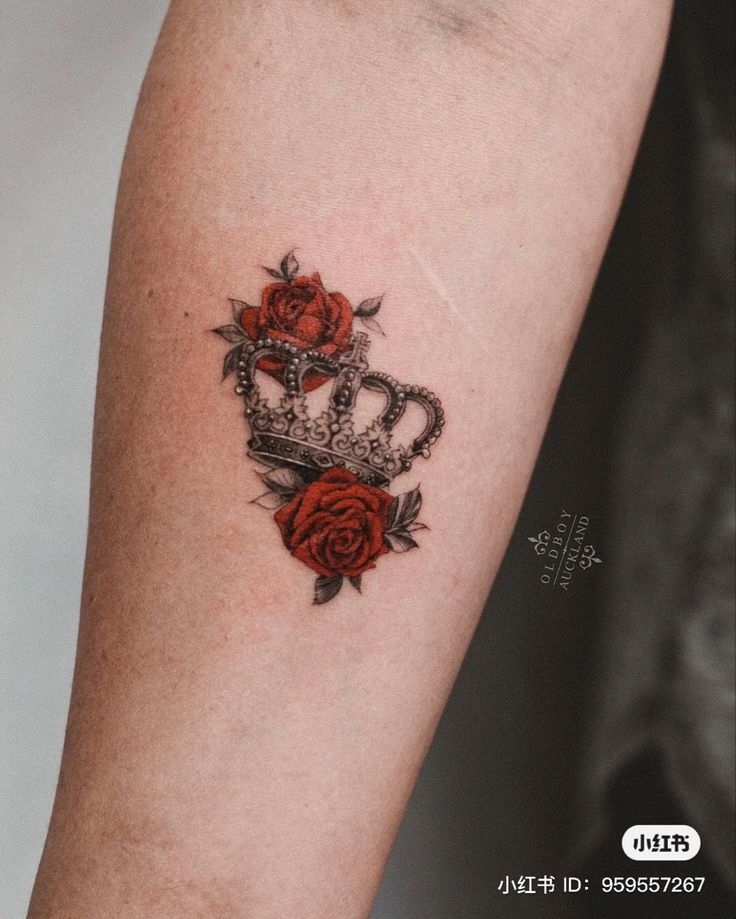 a tattoo with roses and a crown on the left side of the arm is shown