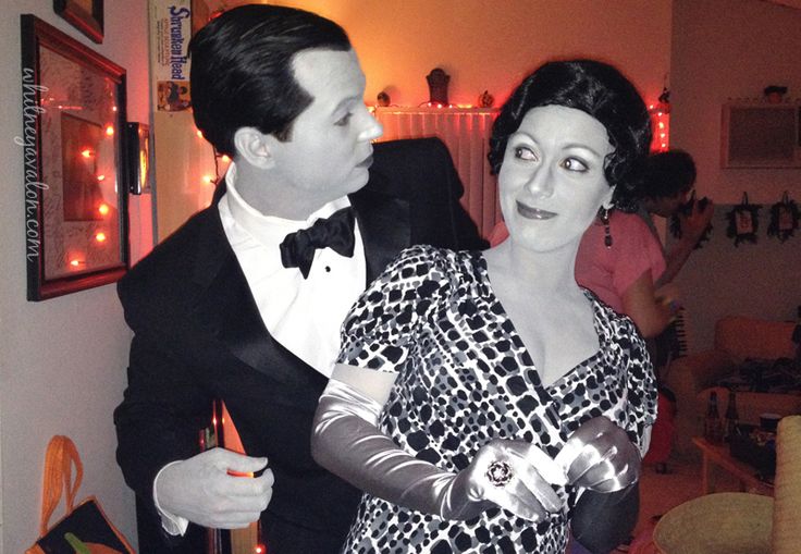 a man in a tuxedo standing next to a woman wearing a dress and gloves