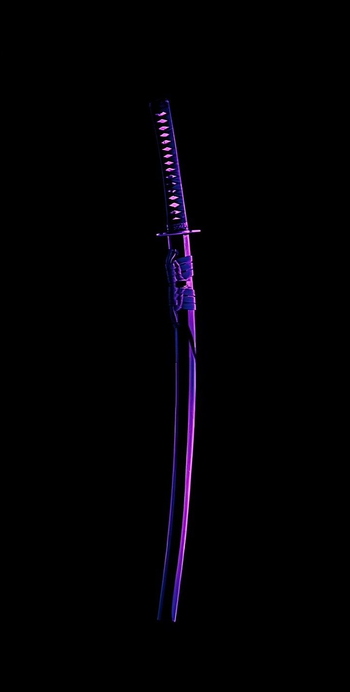 a close up of a purple toothbrush on a black background