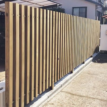 a large wooden fence next to a building