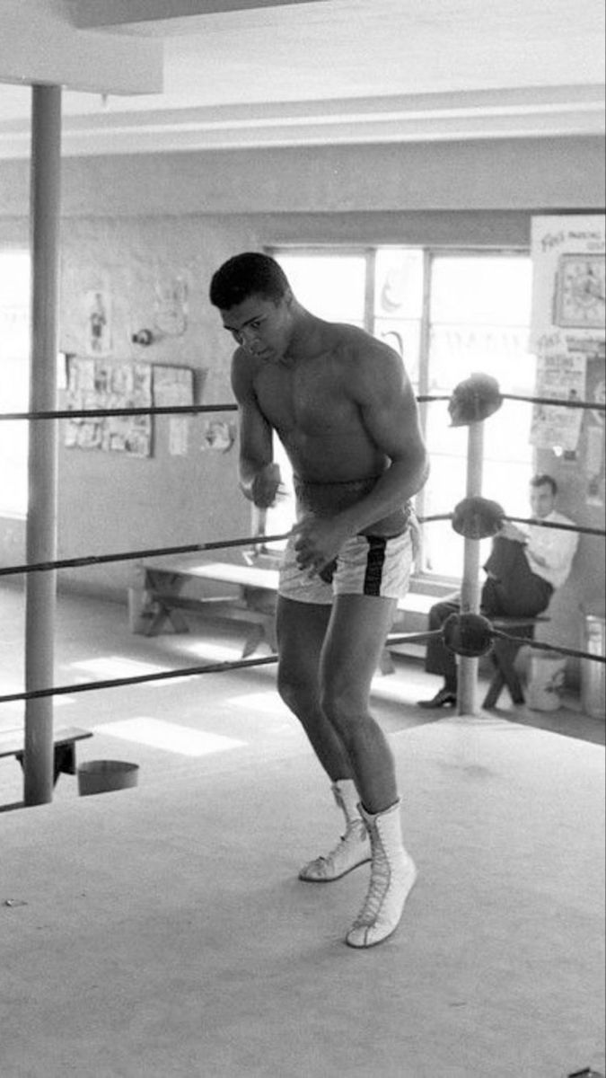 a shirtless man standing in a boxing ring