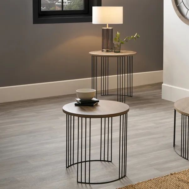 two tables with lamps and a clock on the wall behind them in a living room