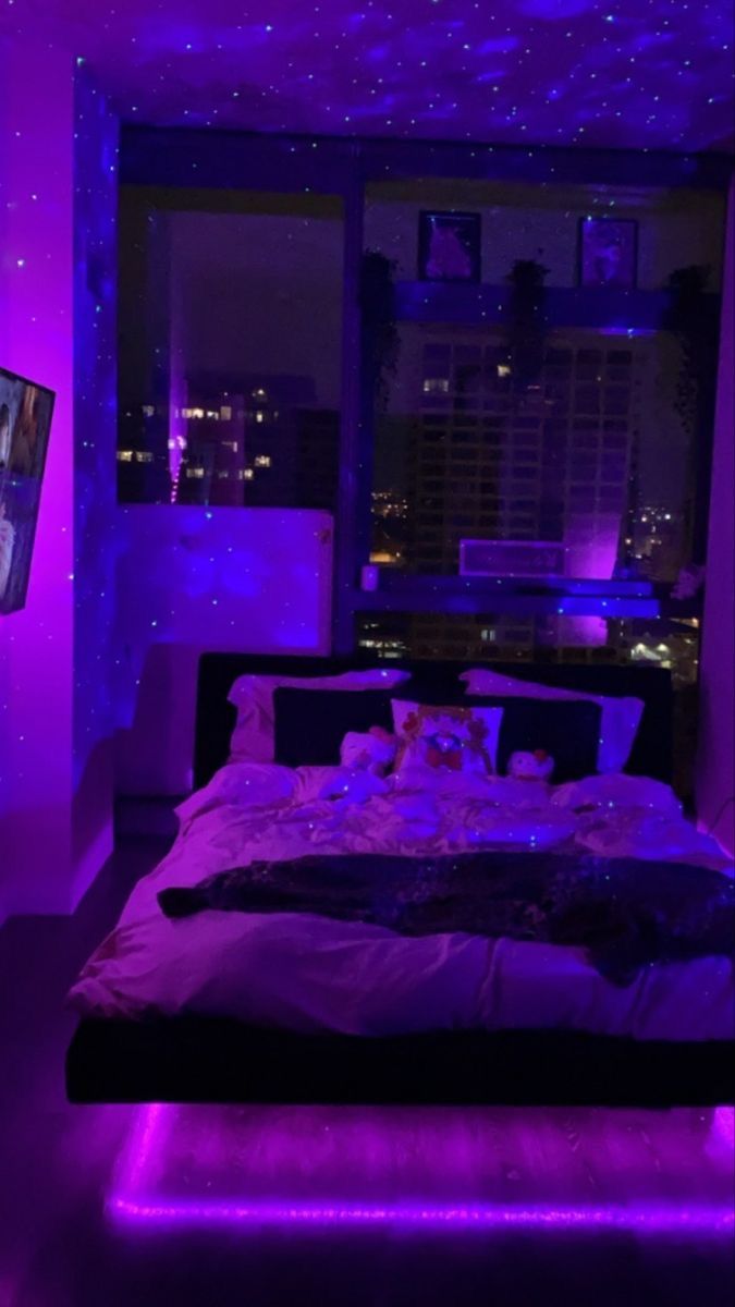 a bed in a room with purple lighting