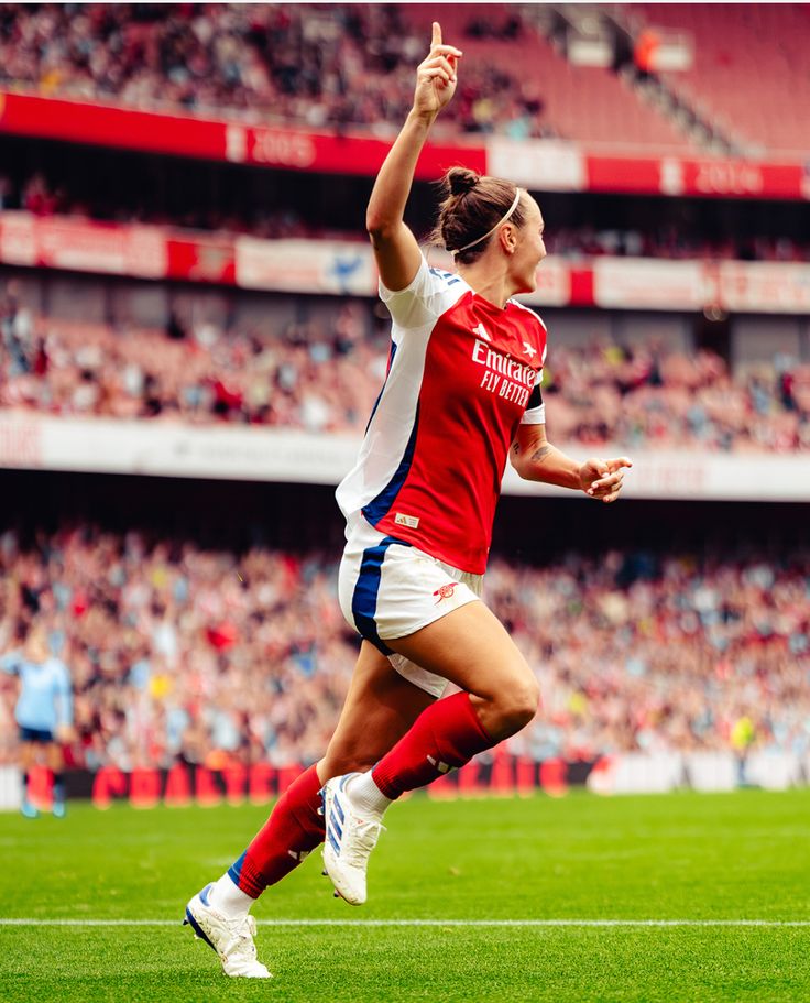 a female soccer player is celebrating her team's victory over the other team in a game