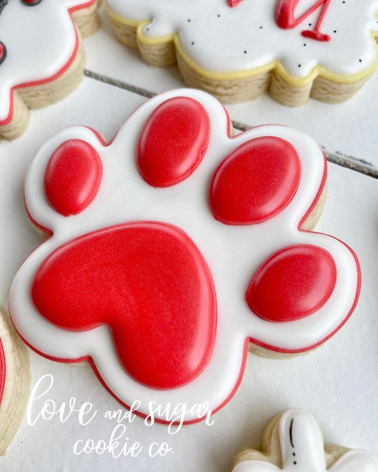 decorated cookies with red and white frosting for a dog's paw