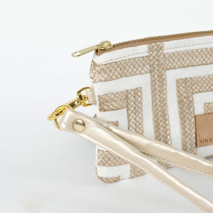 Get ready for a taste of luxury and style with this geometric clip pouch. Its slim profile makes it easy to slip into your pocket and it still has plenty of room for your ID and cards. Make it fancy by attaching the removable wristlet strap and rock it on its own. Handcrafted by our team of women artisans in recovery, 100% of your purchase goes to provide job skills training and career development for the women who made it. Details 100% upcycled materials Dimensions: 5" x 4" Liner: Upcycled fabr Trendy Beige Rectangular Wristlet, Rectangular Wristlet With Adjustable Strap, Cream Rectangular Wristlet With Zipper Pouch, Cream Rectangular Zipper Pouch Wristlet, Cream Rectangular Wristlet With Removable Pouch, Chic Zipper Pouch Wristlet, Cream Rectangular Wristlet With Zipper, Chic Wristlet With Zipper Pouch, Chic Cream Wristlet For Everyday