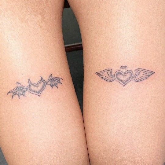 two small tattoos on both legs with hearts and wings in the shape of a heart