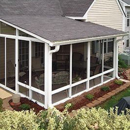 an enclosed patio area with chairs and tables