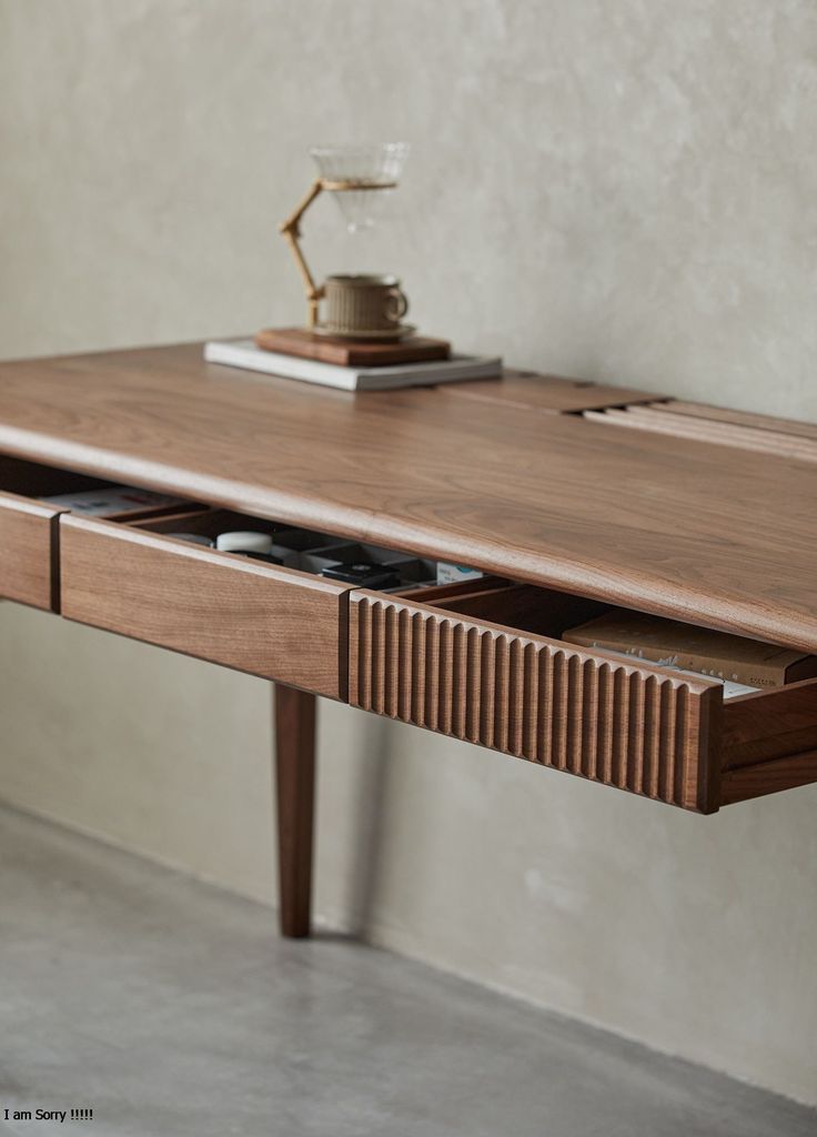 a wooden desk with drawers and a phone on it's side table next to a wall