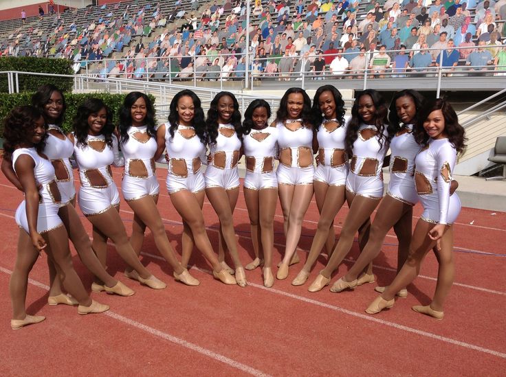 a group of cheerleaders pose for a photo in front of an empty stadium