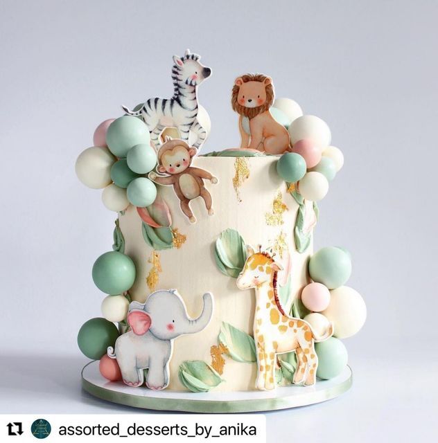 a white cake decorated with animals and balloons