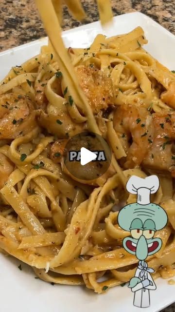 a plate of pasta with shrimp and parmesan cheese on the side, in front of a cartoon character