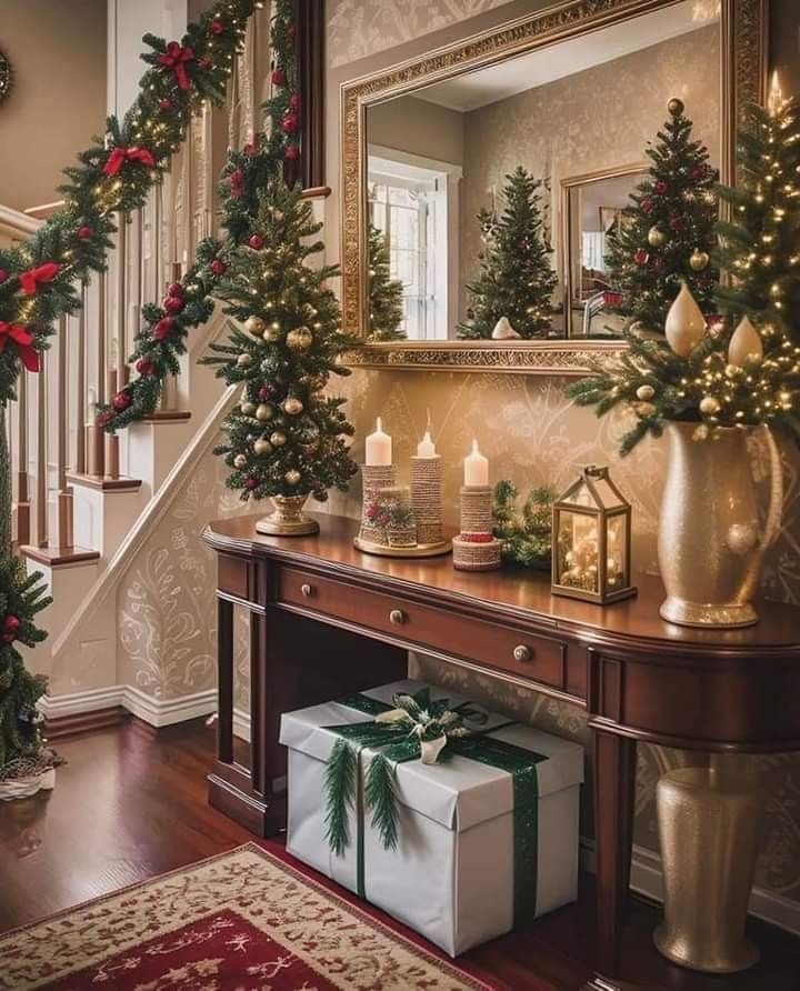 christmas decorations and presents on a table in front of a staircase decorated for the holidays