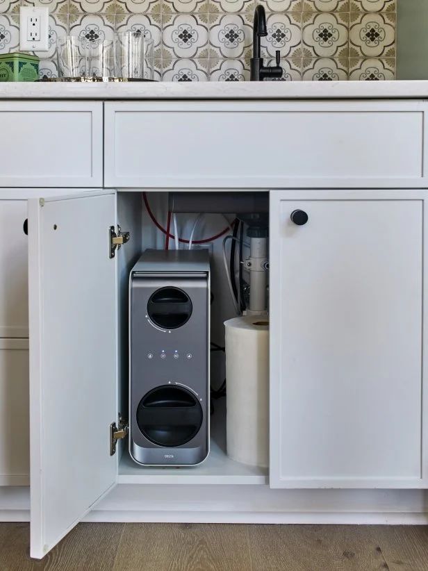 an open cabinet in the middle of a kitchen with white cabinets and countertop space