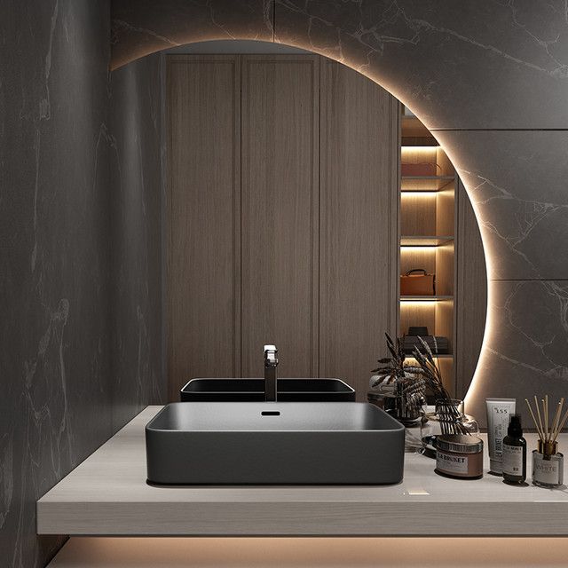 a bathroom sink sitting on top of a counter next to a shelf with candles and other items