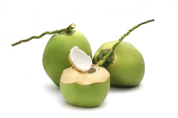 three green coconuts with one cut in half and the other whole, on a white background