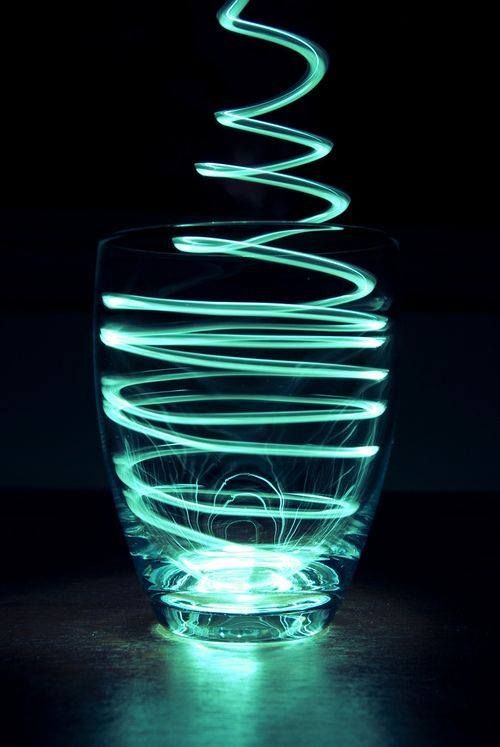 a glass bowl with some lights in the middle of it on a black background,