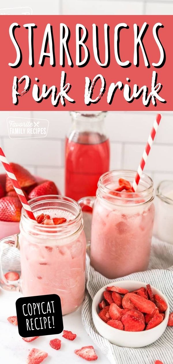 two jars filled with pink drink next to strawberries