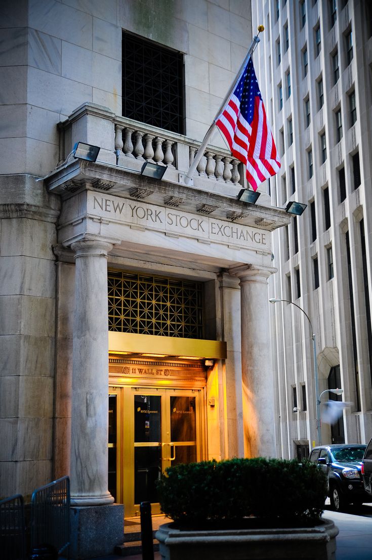 the new york stock exchange building with an american flag on it's front door