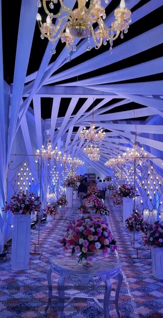 an indoor wedding venue decorated with flowers and chandeliers