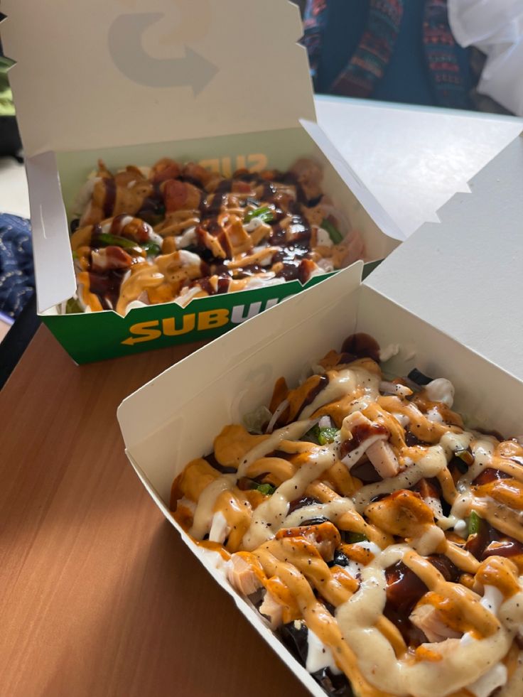 two boxes filled with food sitting on top of a table