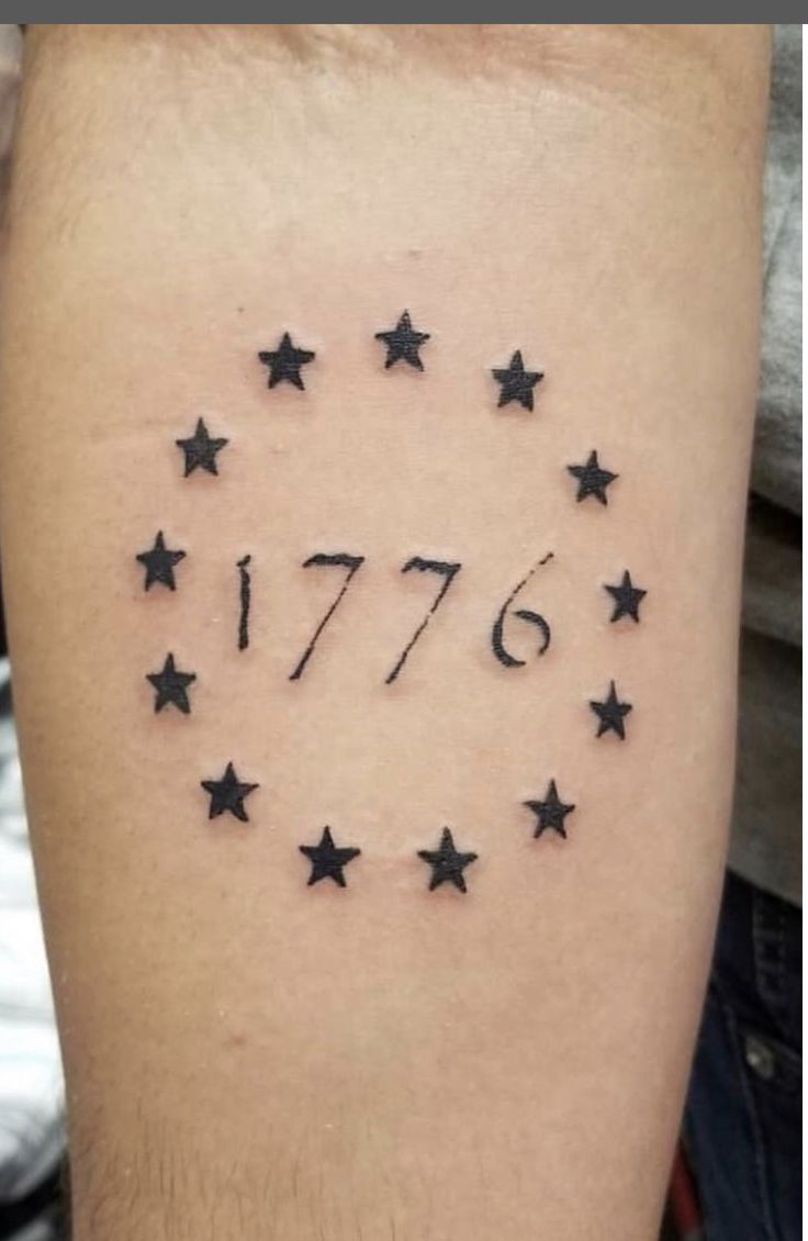 a man's arm with black stars on it and the date 1876 written in white ink