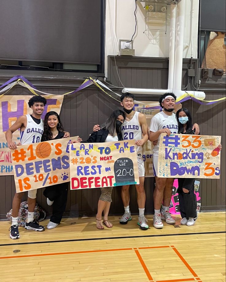 some people holding up signs on a basketball court