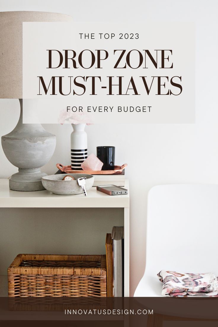 a white table topped with a lamp next to a book shelf and a basket on top of it