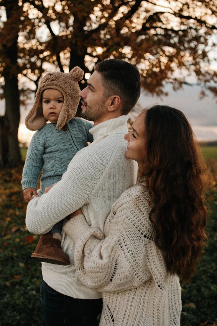 a man and woman holding a baby in their arms