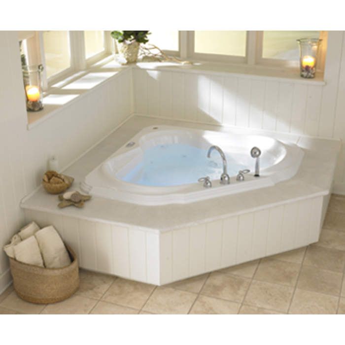 a large jacuzzi tub in a bathroom next to a window with candles on it