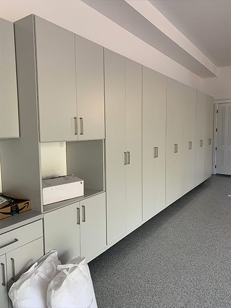 an empty room with white cabinets and gray carpeted flooring is pictured in this image