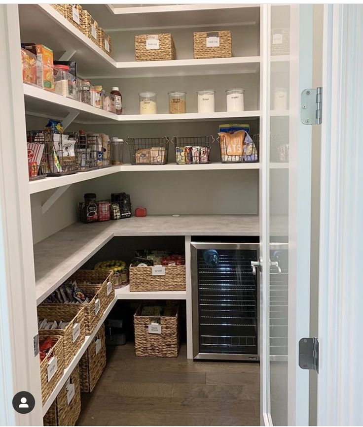 an organized pantry with lots of food in baskets and bins on the bottom shelf