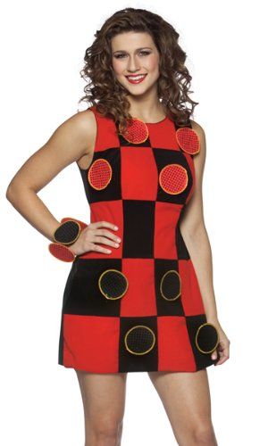 a woman wearing a red and black dress with circles on the chest, standing in front of a white background